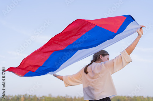 The flag of Russia beautifully waving behind the back of a woman. Russia's Independence Day