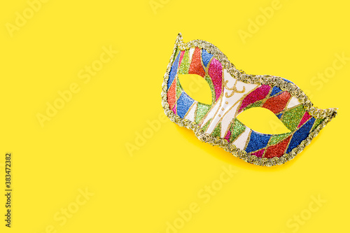 Fototapeta Naklejka Na Ścianę i Meble -  Festive yellow background with colorful carnival mask. Greeting card concept voor birthday, carnival, party. Copy space.