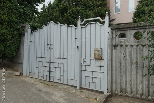 Wallpaper Mural one large gray iron gate and part of a fence wall on a rural street Torontodigital.ca