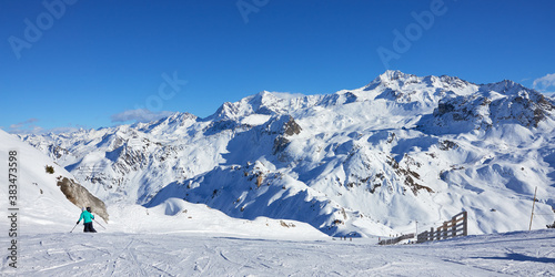 Panoramic view of the slope with mountains in the background near Tignes high-altitude ski resort in France during the winter season.