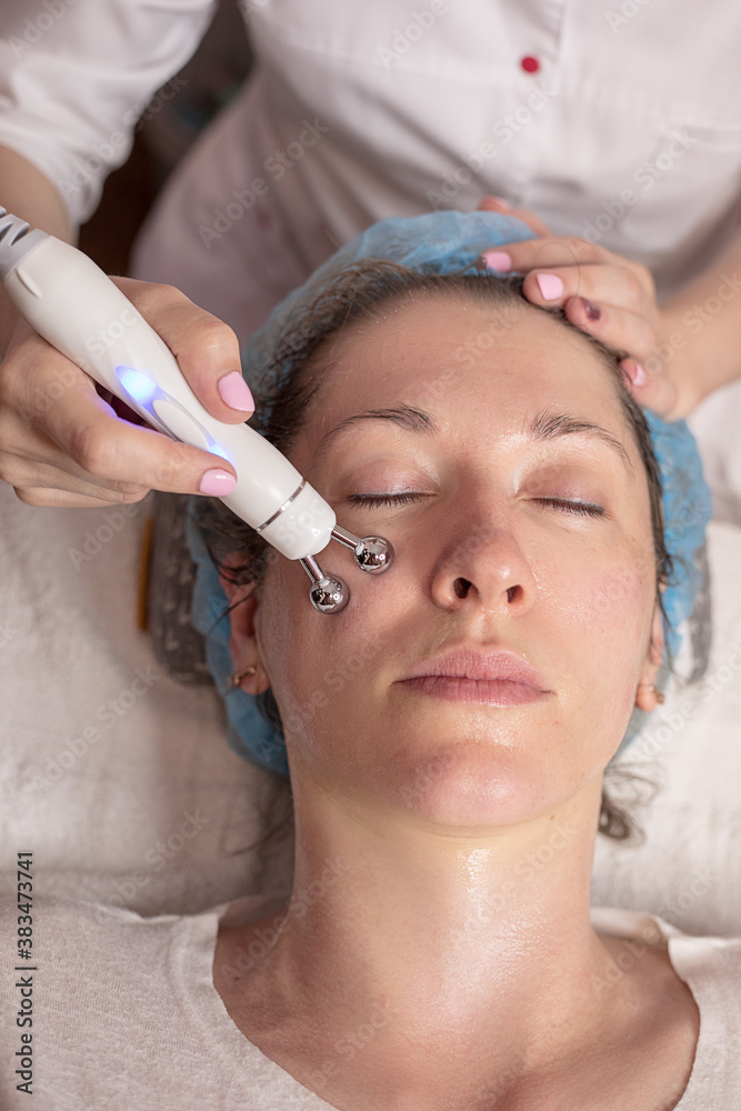 A young woman gets a beauty treatment at the hydro peeling care Spa. Beauty tools. Facial or beautician specialist