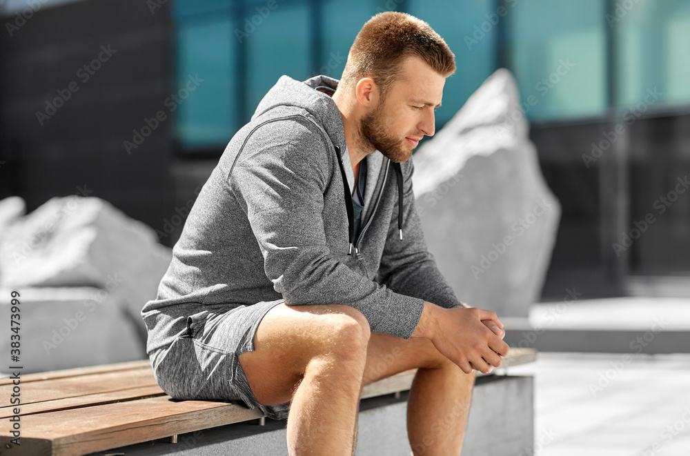 fitness, sport and people concept - young man sitting on bench outdoors fitness, sport and people concept - young man sitting on bench outdoors