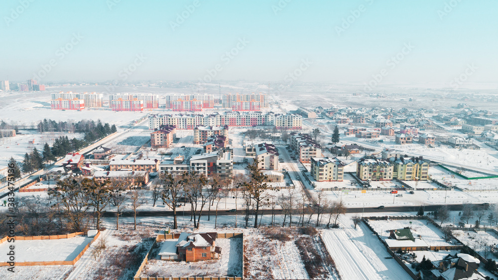 Top view of the winter village with snow covered houses and roads. Aerial view of landscape