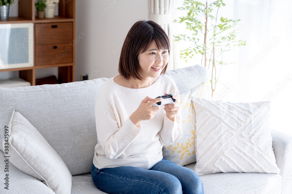 家でゲームをするアジア人女性