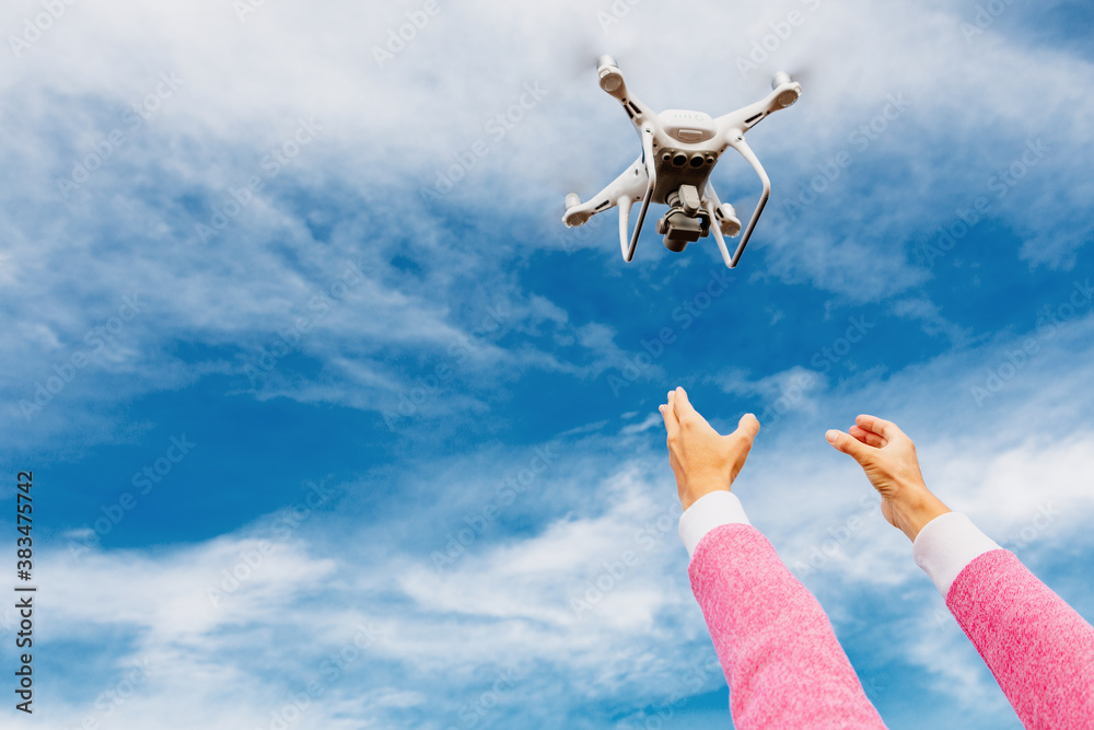 The drone and photographer woman hands on blue sky The drone and photographer woman hands on blue sky