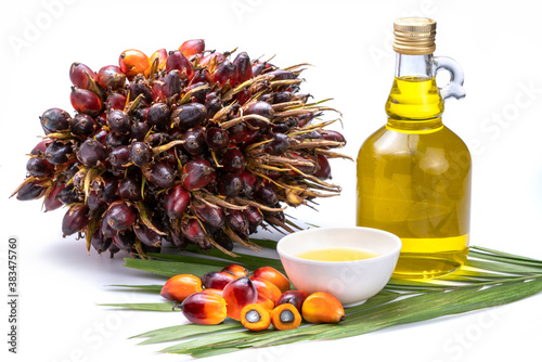 Fresh palm oil fruits and cooking palm oil on a palm leaves in wooden background photo