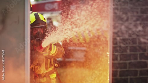 Fireman extinguish fire with the hose. Burning house fire drill. High quality 4k footage photo