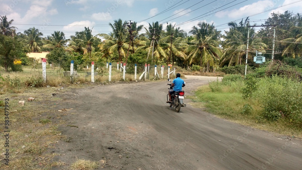 Fototapeta premium person riding a bike on mud road