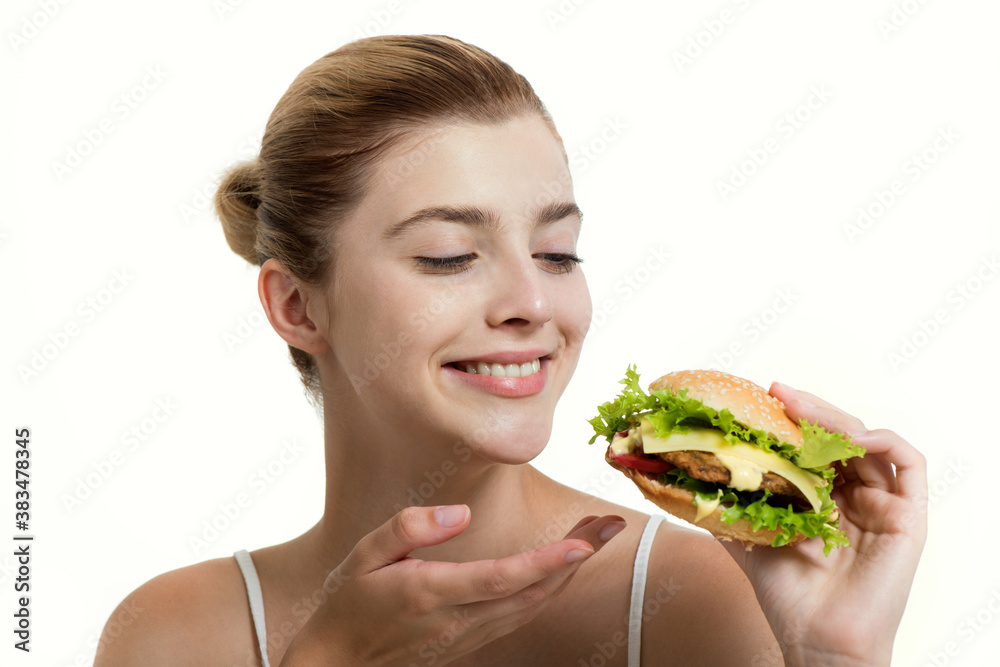 Young beautiful smilling girl holds a burger in hand