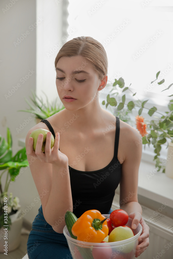 Beautiful young girl holding an apple in her hands. Vegetables and fruits. Beautiful young girl holding an apple in her hands. Vegetables and fruits.