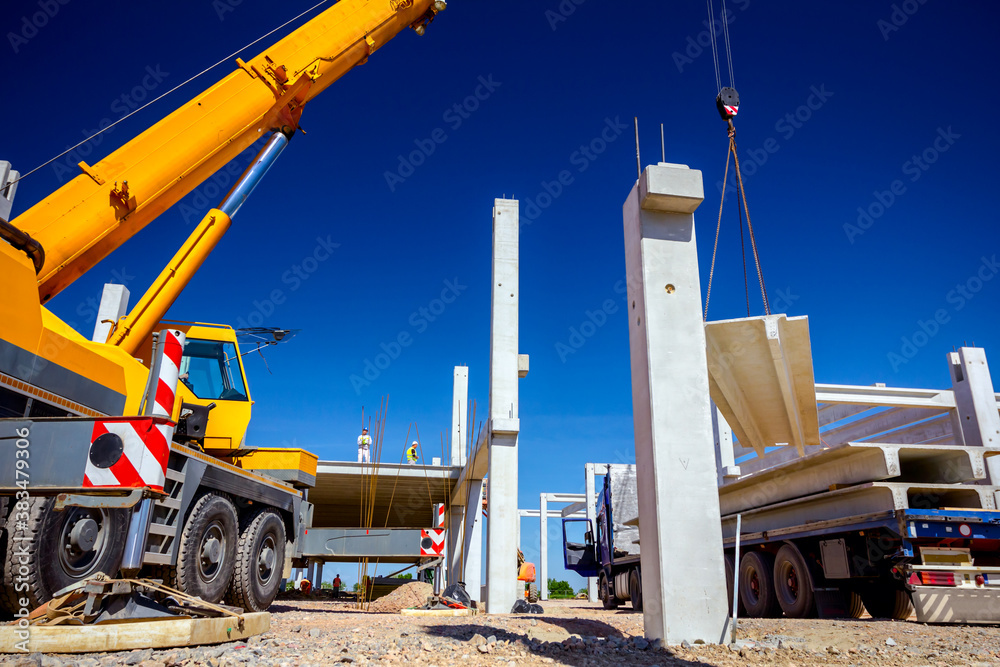 Obraz premium Unloading concrete pillar from truck trailer at construction site