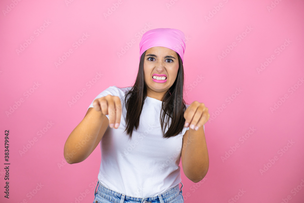 Young beautiful woman wearing pink headscarf over isolated pink background disgusted expression, displeased and fearful doing disgust face because aversion reaction. Annoying concept Young beautiful woman wearing pink headscarf over isolated pink background disgusted expression, displeased and fearful doing disgust face because aversion reaction. Annoying concept