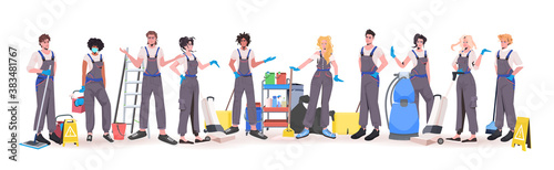 mix race professional office cleaners team standing together janitors in uniform with cleaning equipment full length horizontal vector illustration