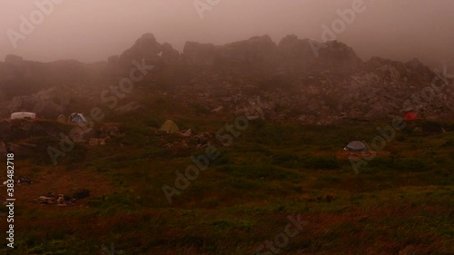 Tent camp in the mountains, camping by the lake, tents removed from the top, rain and fog in the mountains.2020 photo