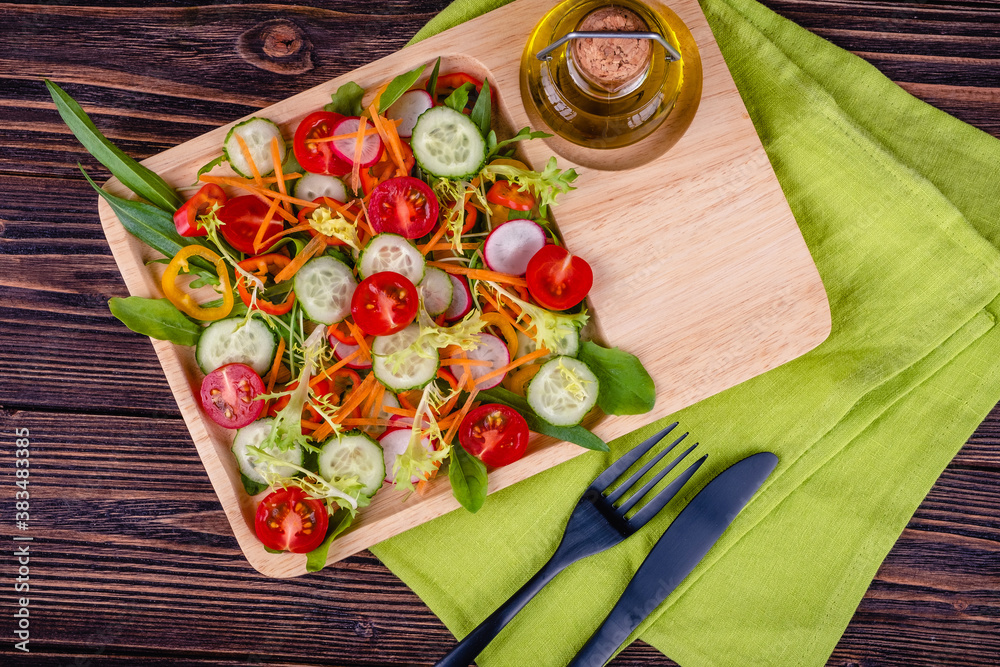 Fresh chopped vegetables on a plate on a wooden table.