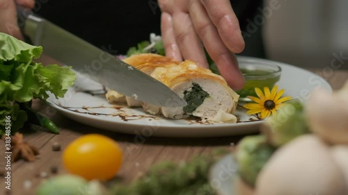 Wallpaper Mural Serving chicken roll with spinach. There are greens and green oil on the plate. Close-up with hands, slow motion. Torontodigital.ca