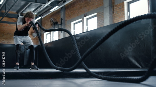 Fotografija Anxious kickboxer training with ropes in sport club