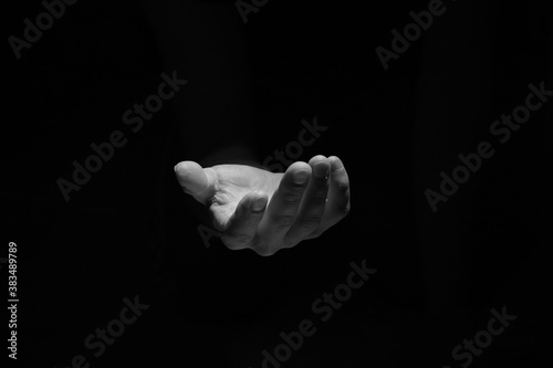 Support hand on a dark background. Helping hand from the dark photo