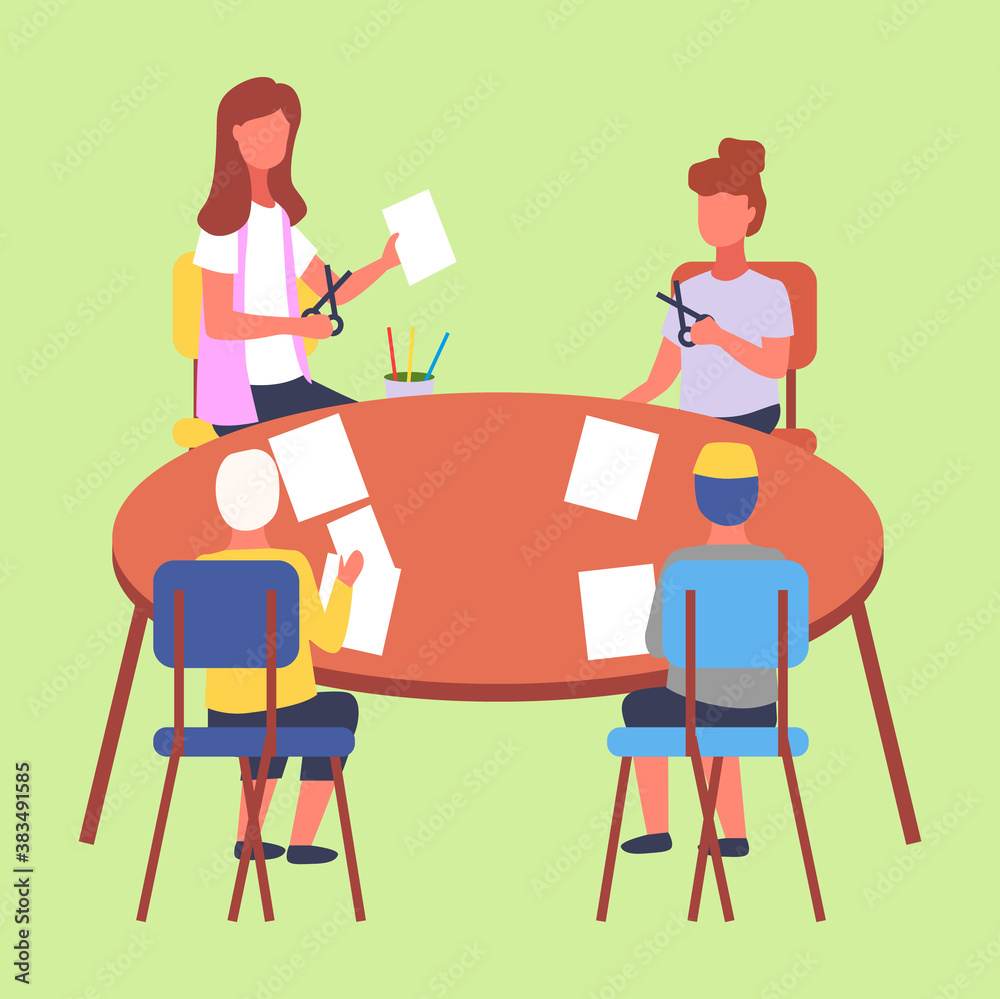 Kids sitting at a table and cutting white paper with scissors. Art lesson in modern kindergarten. A teacher conducts a master crafts paper lesson with a group of children. Children s education concept