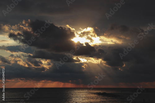 Sunset over the sea, sunshine coming through the clouds