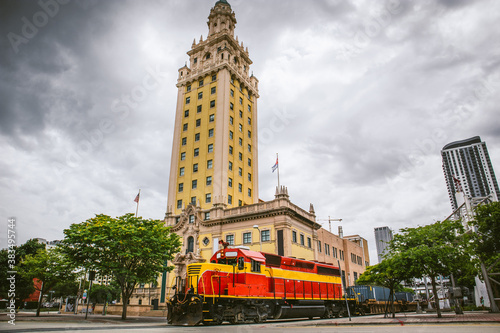 Train crosses Biscayne Boulevard in front of Freedom Tower to get to the port of Miami
