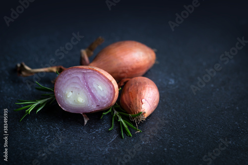 Schalotten und Rosmarin auf einem dunklen Hintergrund