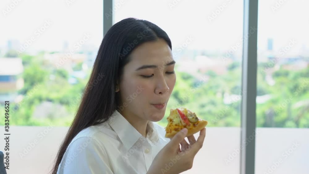 Asian young woman enjoy eating a piece of pizza Asian young woman enjoy eating a piece of pizza