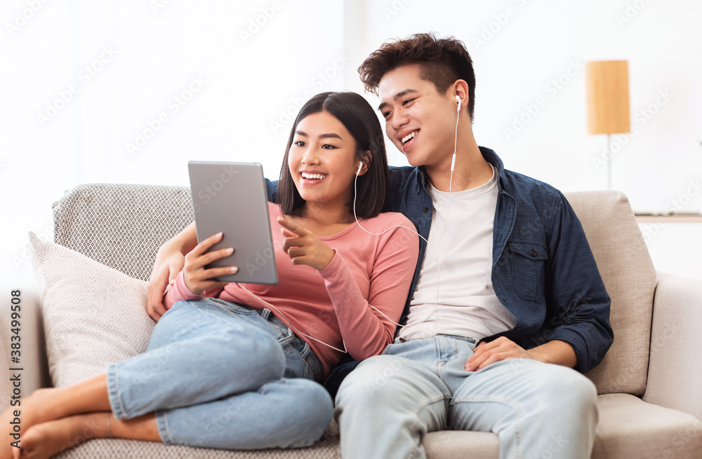 Cheerful Asian Couple Using Digital Tablet Browsing Internet At Home Cheerful Asian Couple Using Digital Tablet Browsing Internet At Home