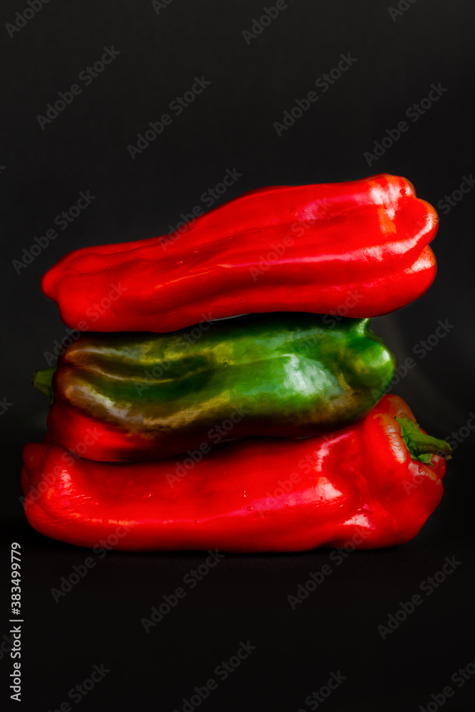 art still life of three red and green sweet peppers on black background, group of glossy paprika lying on top of each other isolated, low key advertising poster art still life of three red and green sweet peppers on black background, group of glossy paprika lying on top of each other isolated, low key advertising poster