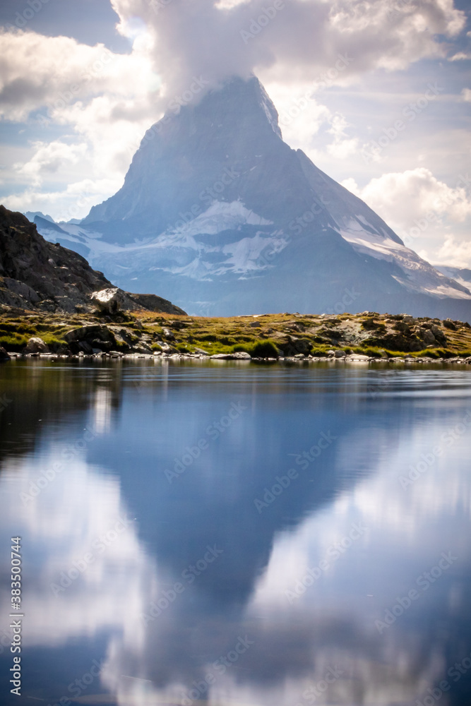 Matterhorn reflection in a small lake in the Alps of Switzerland on a summer day.