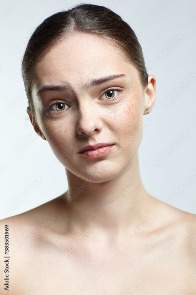 Headshot of emotional female face portrait with regretful, facial expression. Headshot of emotional female face portrait with regretful, facial expression.