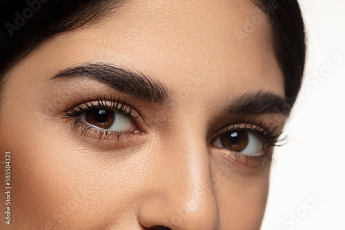 Close-up shoot of beautiful female eyes and cheeks isolated on white studio background. Beauty, fashion, skincare, cosmetics, ad concept. Copyspace. Well-kept skin and natural fresh look. Healthy