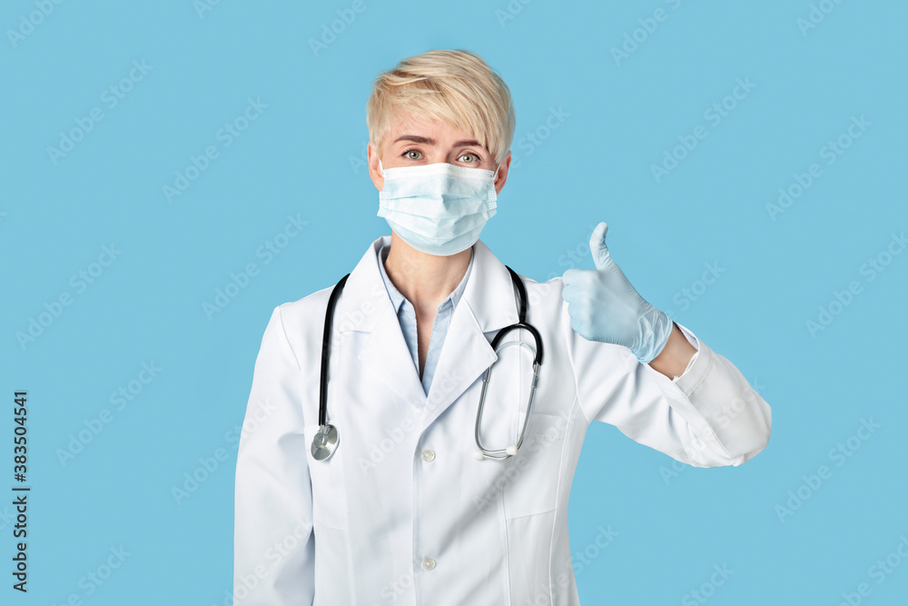 Great medical care, prevent disease and quarantine. Middle aged woman doctor in rubber gloves shows thumbs up Great medical care, prevent disease and quarantine. Middle aged woman doctor in rubber gloves shows thumbs up