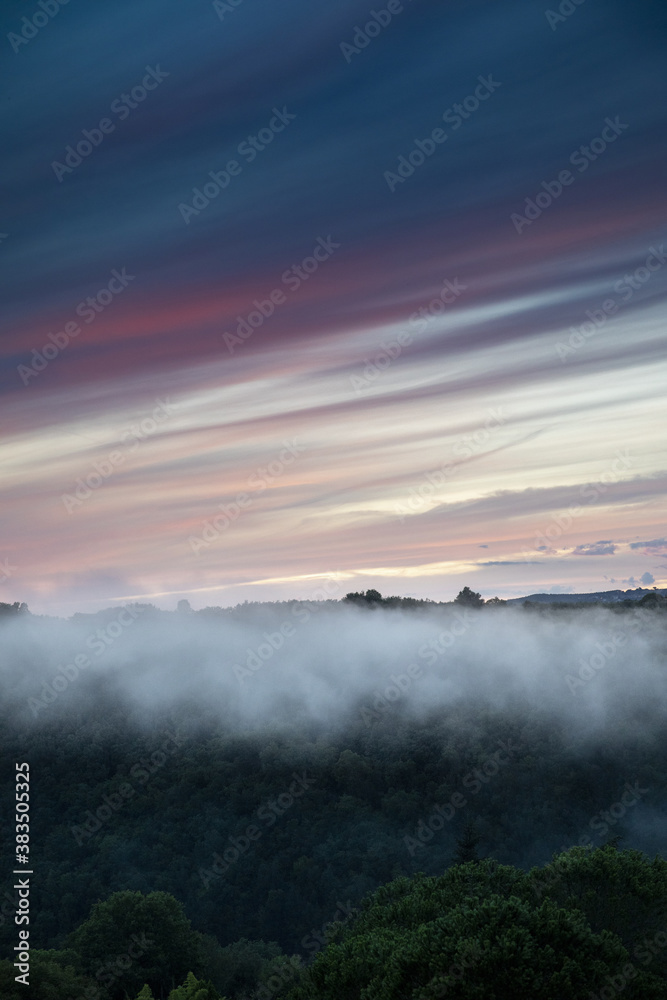 Fototapeta premium Abend Nebel über Landschaft mit bewaldetem Tal