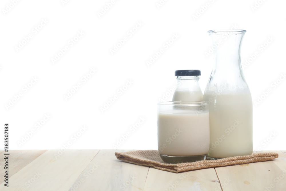 Milk in glass and in jar on table isolated on white background Milk in glass and in jar on table isolated on white background