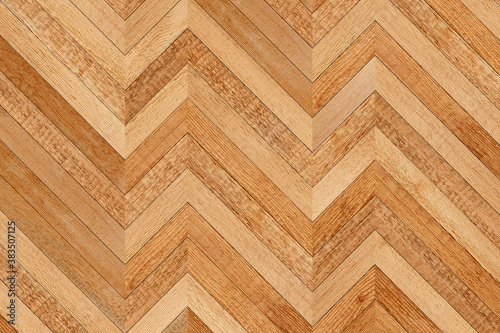 Wooden planks texture. Light brown parquet floor with chevron pattern. Wooden background. 
