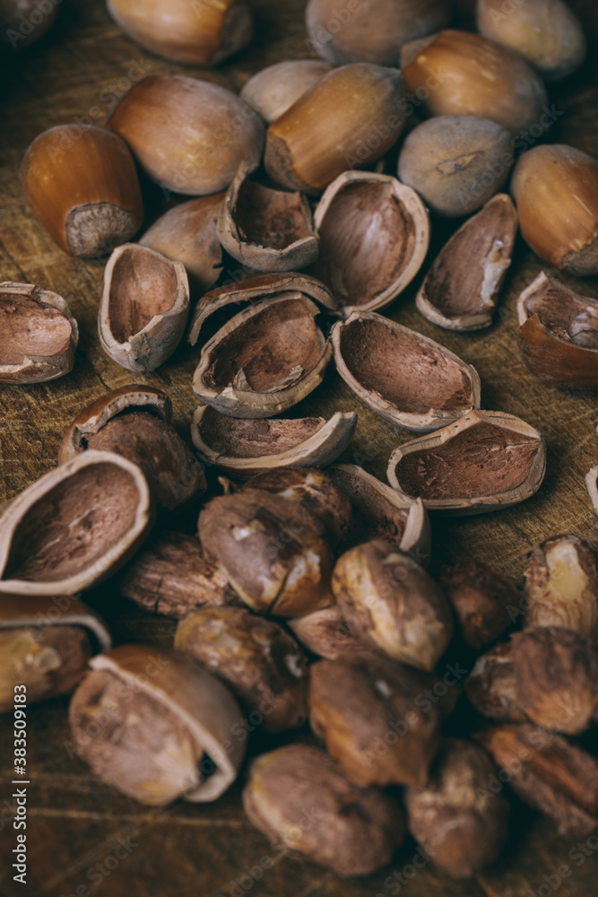 Whole nuts, shelled nuts and shells. Corylus avellana. Macro photo, close up, on wooden table. Whole nuts, shelled nuts and shells. Corylus avellana. Macro photo, close up, on wooden table.