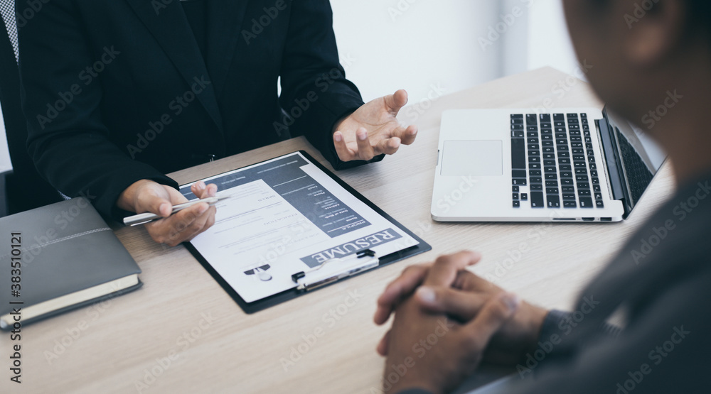 HR head is interviewing a young man's job application in a private room. HR head is interviewing a young man's job application in a private room.