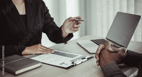 HR head is interviewing a young man's job application in a private room.