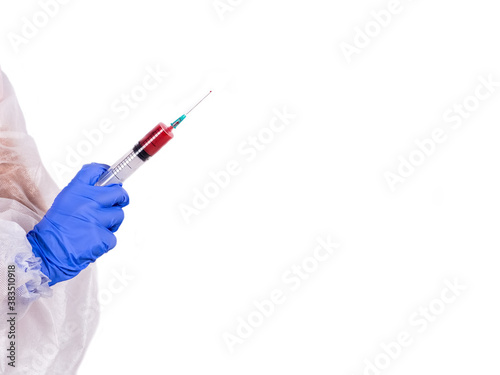 A hand with a blue glove holds a syringe with a red liquid on a white background. Sample and blood in the syringe. Medicine concept. Isolated.