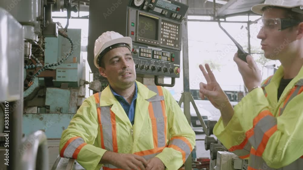 Two young maintenance man in uniform checking on machine and calling with radio phone at industrial factory, engineer and labor checking and inspector machinery with problem technical. Two young maintenance man in uniform checking on machine and calling with radio phone at industrial factory, engineer and labor checking and inspector machinery with problem technical.