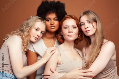 young pretty african and caucasian women posing cheerful together on brown background  lifestyle diverse nationality people concept