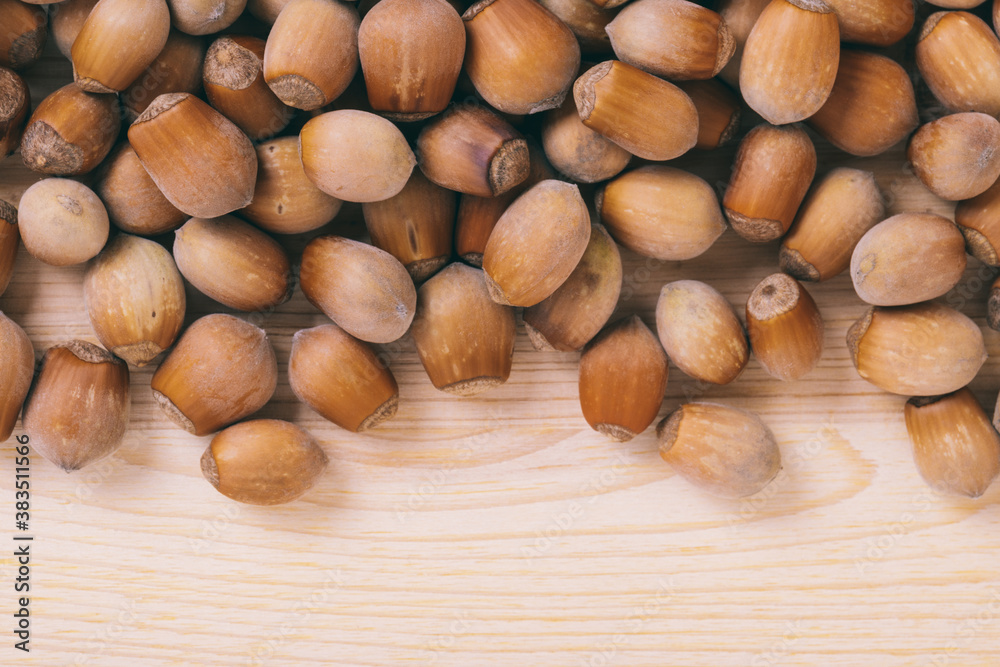 Pile of nuts. Whole nuts. Corylus avellana. Macro photo, close up, top view on wooden table. Pile of nuts. Whole nuts. Corylus avellana. Macro photo, close up, top view on wooden table.