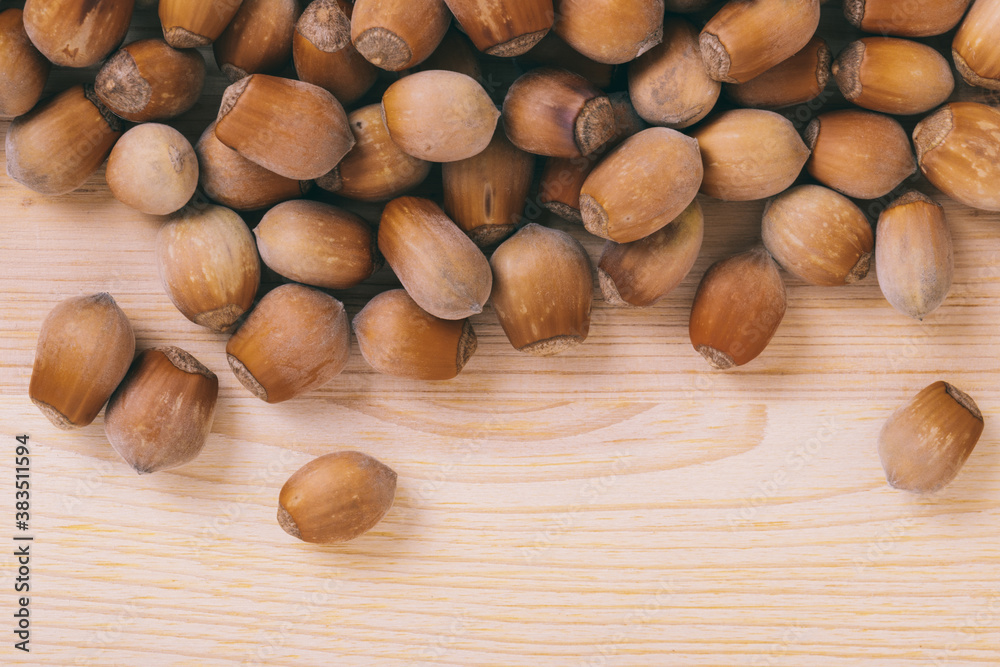 Pile of nuts. Whole nuts. Corylus avellana. Macro photo, close up, top view on wooden table. Pile of nuts. Whole nuts. Corylus avellana. Macro photo, close up, top view on wooden table.