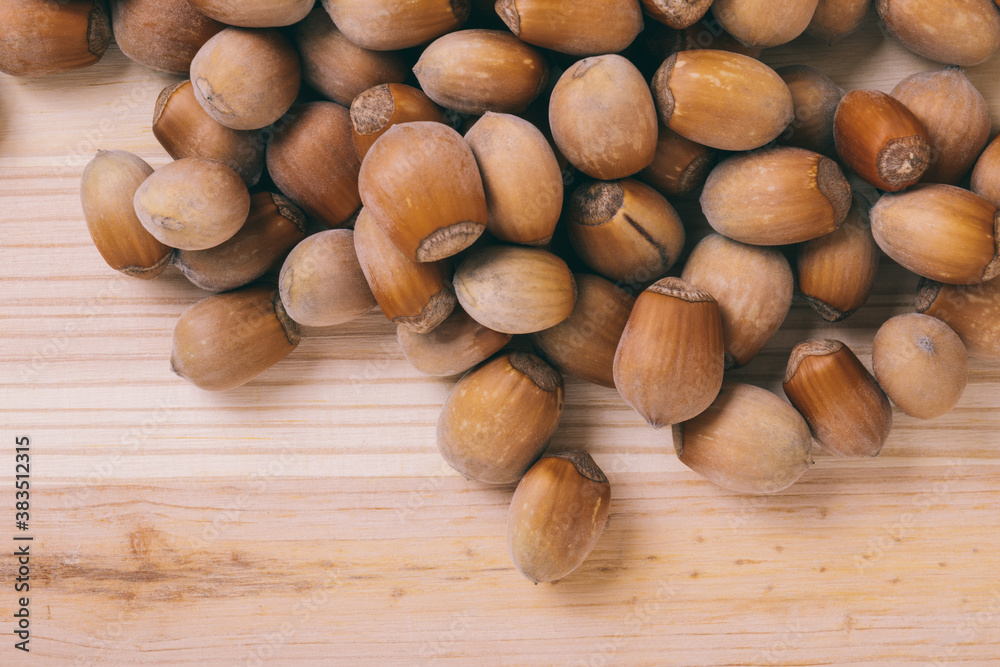 Pile of nuts. Whole nuts. Corylus avellana. Macro photo, close up, top view on wooden table. Pile of nuts. Whole nuts. Corylus avellana. Macro photo, close up, top view on wooden table.