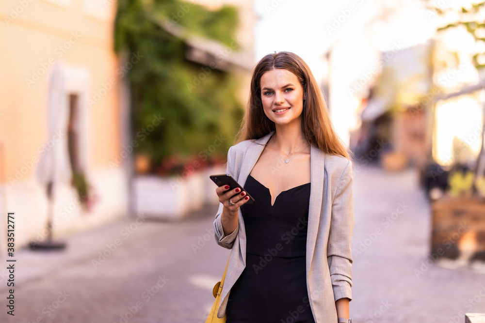 Young woman walking and using a smart phone in the street in a day
