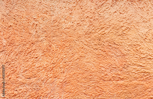 Texture of orange building plaster. Clay (concrete) textured pattern on the wall. Textured orange alabaster surface. Abstract bright background.