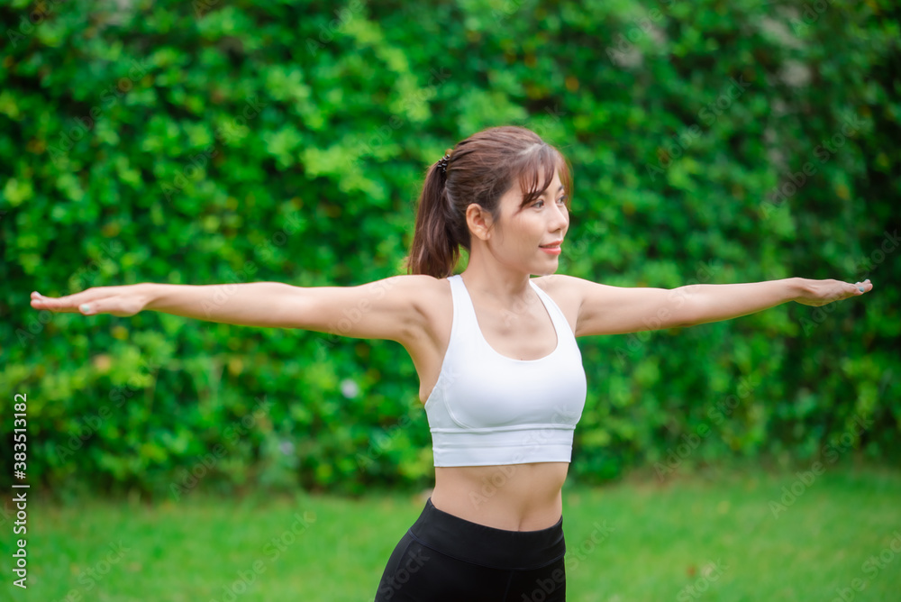 Young asian women warm up in a park before jogging.