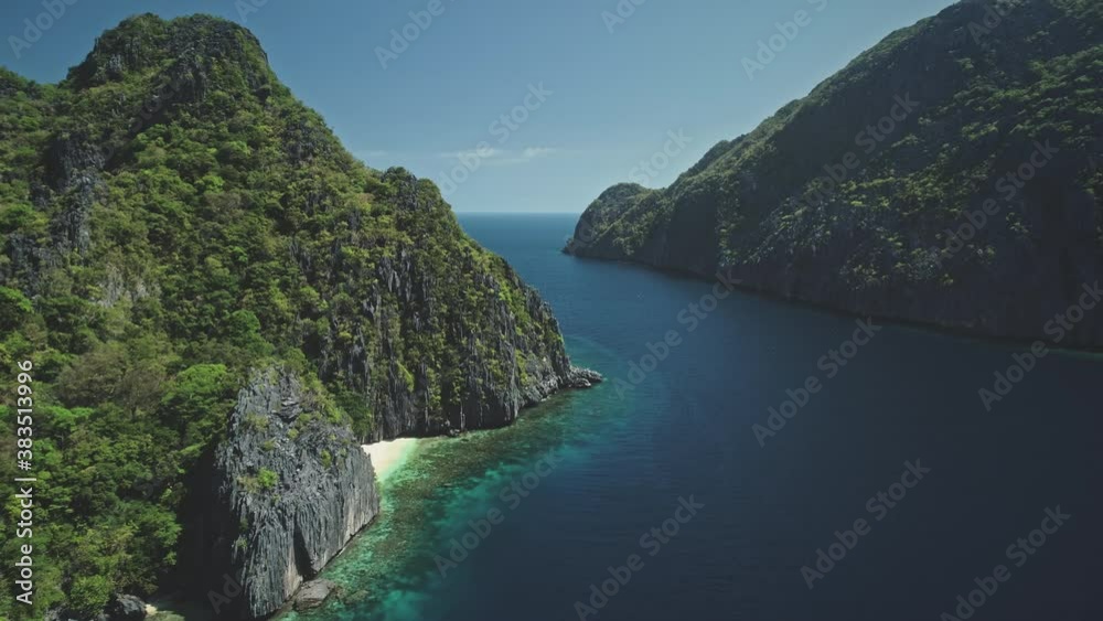 Green tropic mountain island nature at ocean bay aerial panorama view. Amazing greenery mount ranges with tropical forest and plants. Epic seascape of sea coast water at soft light drone shot