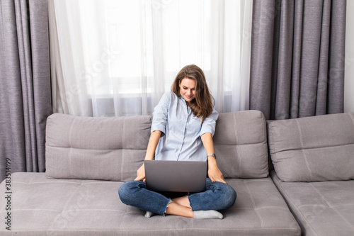 Frustrated sad woman feeling tired worried about problem sitting on sofa with laptop.